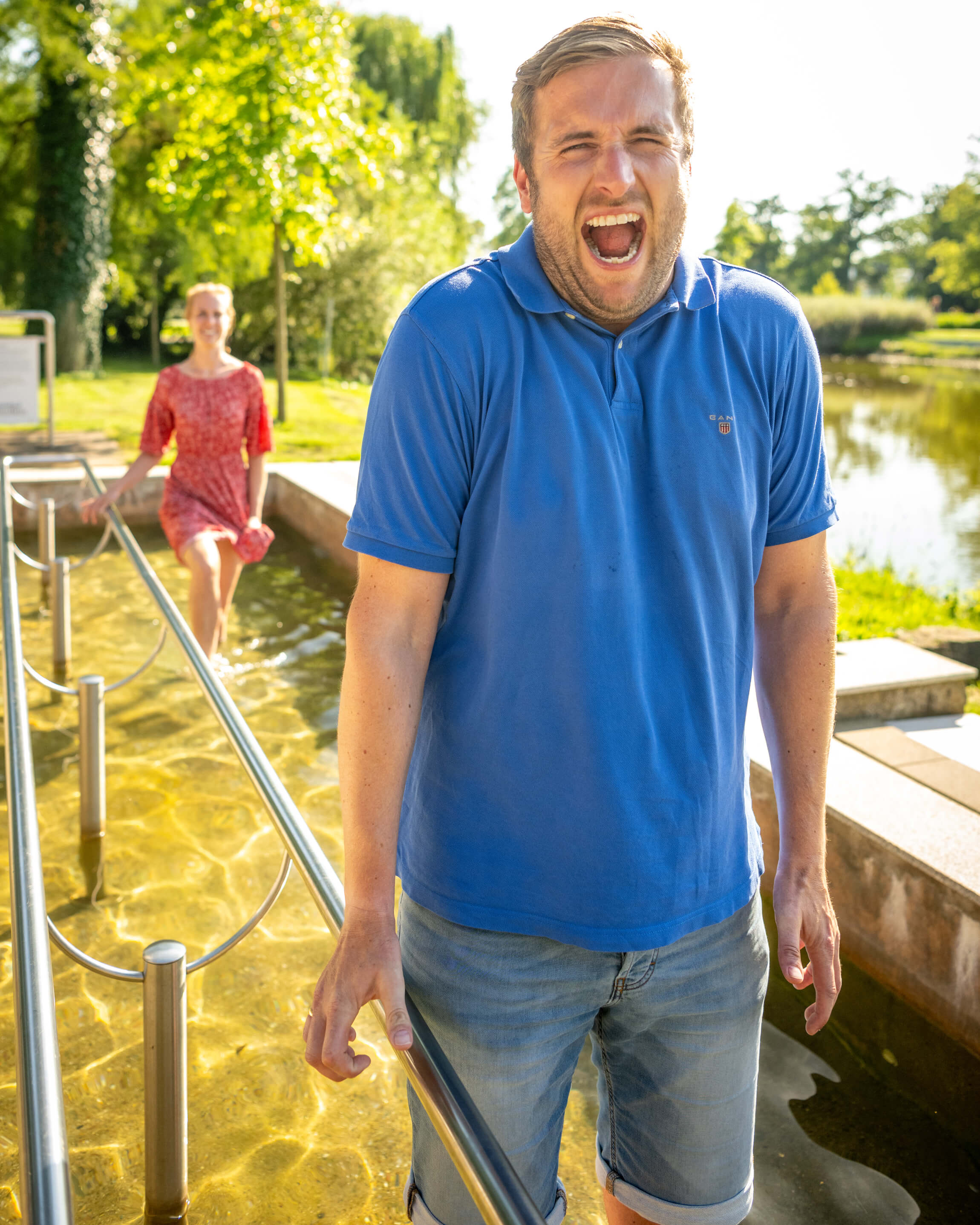 Mann verzieht scherzhaft vor Kälte das Gesicht im Kneippschen' Wassertretbecken