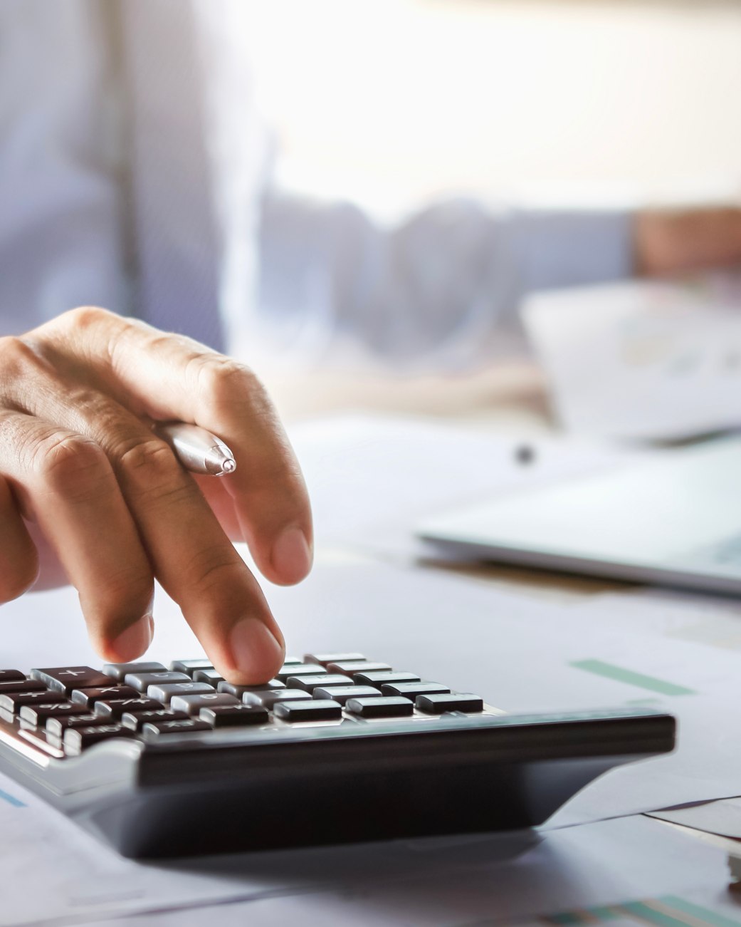 Eine Hand tippt auf einem Taschenrechner auf einem Schreibtisch, © stock.adobe.com | lovelyday12 Eine Hand tippt auf einem Taschenrechner auf einem Schreibtisch, © stock.adobe.com | lovelyday12