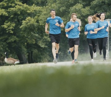 Mehrere Läufer sind zu sehen, sie tragen das gleiche blaue Outfit