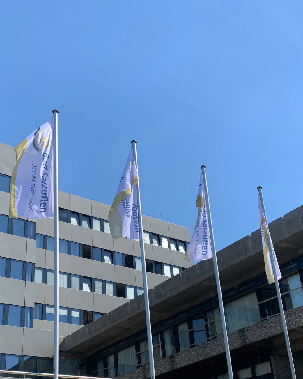 Vier Fahnen hängen an Fahnenmasten im Wind vor dem Rathaus der Stadt. Die Fahnen haben die Aufschriften - Bad Salzuflen...ich fühl mich wohl - und - Herzlich Willkommen - , © Stadt Bad Salzuflen