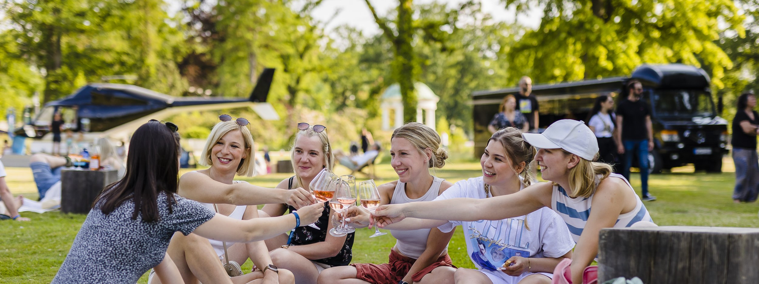Eine Gruppe von Menschen sitzt auf einer Picknick-Decke im Kurpark und trinkt Wein bei einer Veranstaltung., © Stadt Bad Salzuflen | M. Gnoth