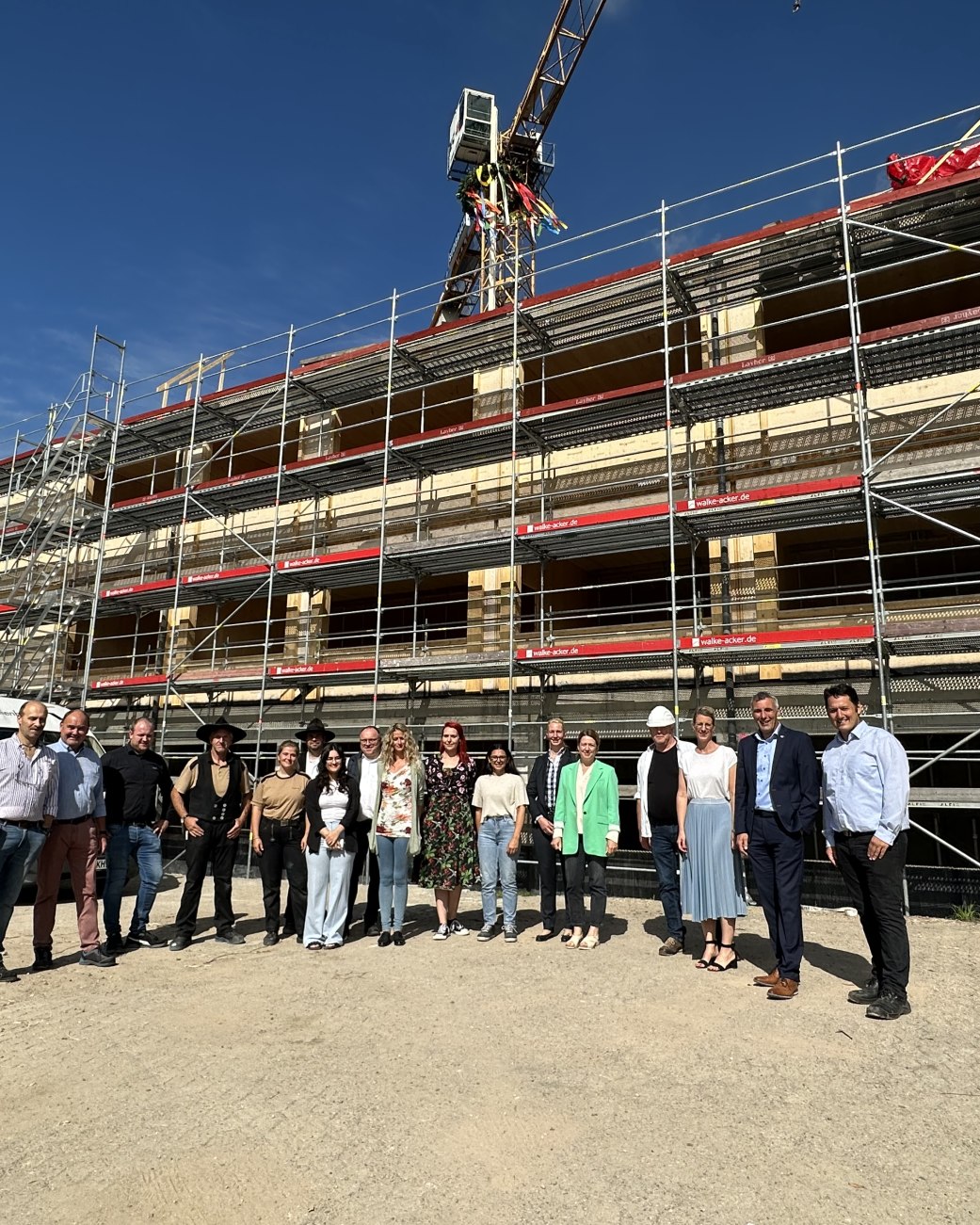 Vertreter*innen von Verwaltung, Politik und Firmen posieren vor dem fertiggestellten Rohbau der neuen Hauptschule Lohfeld, © Stadt Bad Salzuflen