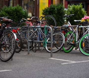 Mehrere Fahrräder sind an drei Fahrradständern in der Innenstadt abgestellt, © ADFC | April Agentur