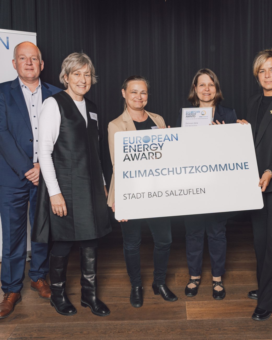 Im Rahmen einer Preisverleihung in Düsseldorf wurde die Stadt Bad Salzuflen erfolgreich für das Qualitätsmanagement
European Energy Award rezertifiziert. Bei der Urkundenübergabe dabei waren (von links) Reiner Tippkötter (energielenker projects GmbH, Greven) Ilga Schwidder (Geschäftsführerin Bundesgeschäftsstelle European Energy Award),
Ulrike Niebuhr (Fachbereichsleiterin Stadtentwicklung und Umwelt, Stadt Bad Salzuflen), Susanne Lübker (Energie-
Team & Fachbereich Stadtentwicklung und Umwelt, Stadt Bad Salzuflen) sowie Mona Neubaur (Ministerin für Wirtschaft, Industrie, Klimaschutz und Energie des Landes NRW)., © Bundesgeschäftsstelle European Energy Award Im Rahmen einer Preisverleihung in Düsseldorf wurde die Stadt Bad Salzuflen erfolgreich für das Qualitätsmanagement
European Energy Award rezertifiziert. Bei der Urkundenübergabe dabei waren (von links) Reiner Tippkötter (energielenker projects GmbH, Greven) Ilga Schwidder (Geschäftsführerin Bundesgeschäftsstelle European Energy Award),
Ulrike Niebuhr (Fachbereichsleiterin Stadtentwicklung und Umwelt, Stadt Bad Salzuflen), Susanne Lübker (Energie-
Team & Fachbereich Stadtentwicklung und Umwelt, Stadt Bad Salzuflen) sowie Mona Neubaur (Ministerin für Wirtschaft, Industrie, Klimaschutz und Energie des Landes NRW)., © Bundesgeschäftsstelle European Energy Award