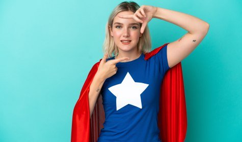 Zu sehen ist eine junge Frau in einem Superheldenkostüm