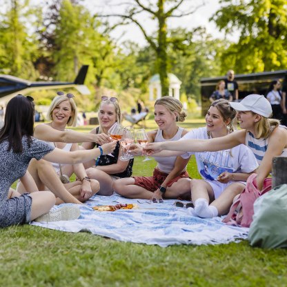 Eine Gruppe von Menschen sitzt auf einer Picknick-Decke im Kurpark und trinkt Wein bei einer Veranstaltung., © Stadt Bad Salzuflen | M. Gnoth Eine Gruppe von Menschen sitzt auf einer Picknick-Decke im Kurpark und trinkt Wein bei einer Veranstaltung., © Stadt Bad Salzuflen | M. Gnoth