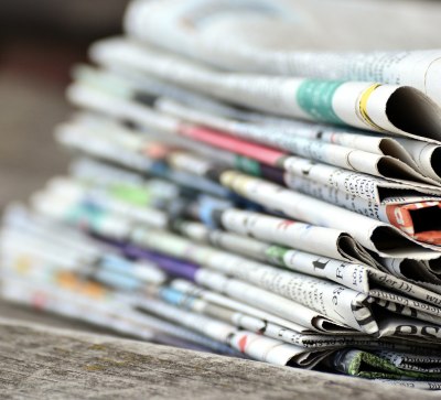 Mehrere Zeitungen liegen aufeinandergestapelt herum