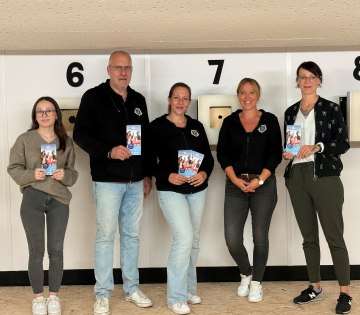 Sportlich aktiv mit &bdquo;Sporteln & Familienspa&szlig;&ldquo; auch 2026/2027: Als eines von acht Freizeittipps l&auml;dt die Sch&uuml;tzengesellschaft Sch&ouml;tmar von 1732 e.V. dazu ein, das Sportschie&szlig;en an einer RedDot-Anlage mit Lasergewehr zu testen. Ausprobiert haben dies (von links) Lenya Tomak (Stab Ehrenamt & Sport, Stadt Bad Salzuflen), die Sch&uuml;tzengesellschaftsmitglieder Christian Hellmich, Bettina Hellmich und Janina Balk sowie Sybille L&uuml;decke (Koordinatorin &bdquo;Lokales B&uuml;ndnis f&uuml;r Familien&ldquo;, Stadt Bad Salzuflen)., &copy; Stadt Bad Salzuflen