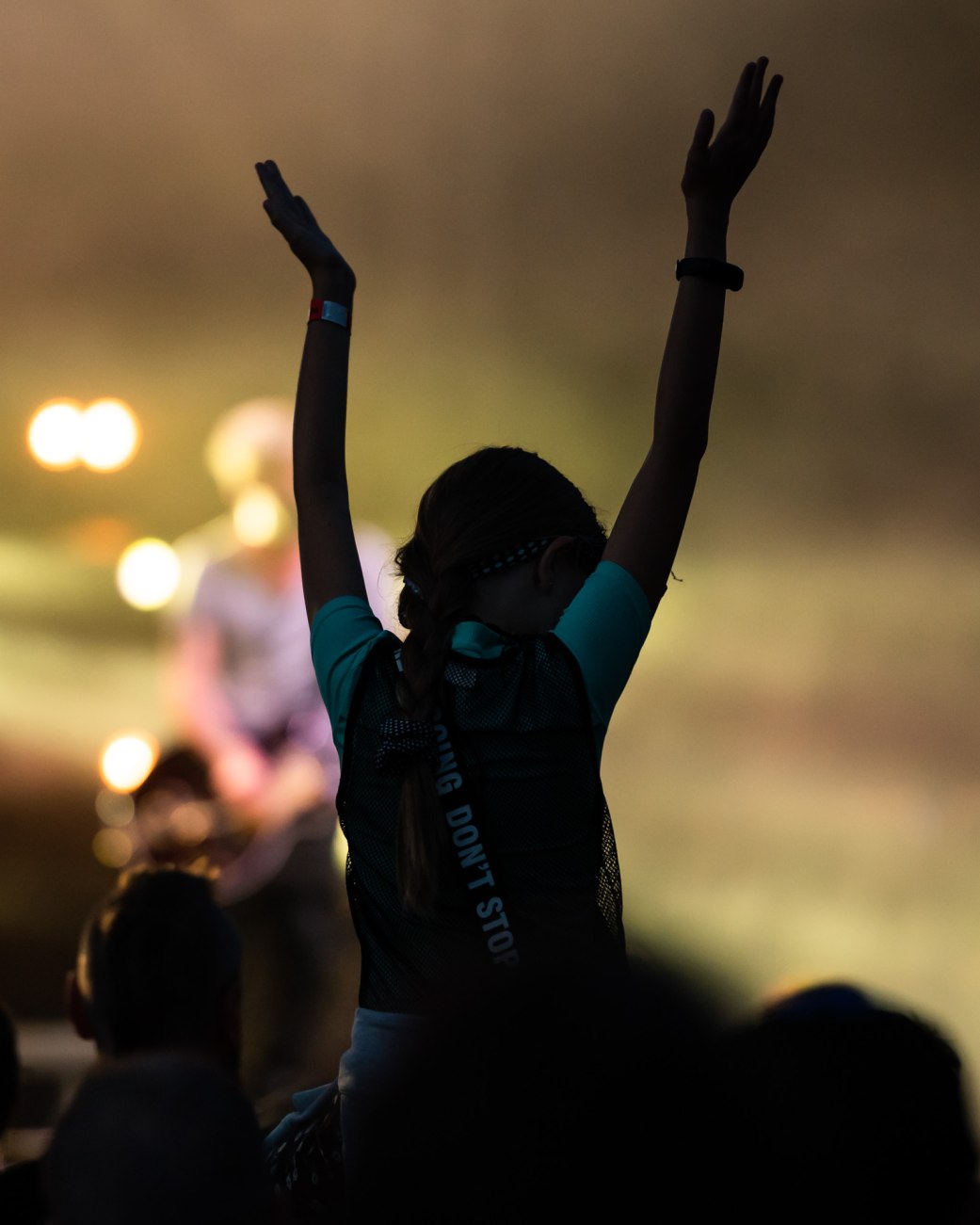 Zu sehen ist das Publikum auf einem Festival. Eine Frau sitzt auf den Schultern eines anderen Menschen und reckt die Hände in die Luft., © stock.adobe.com - Dziurek 