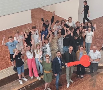 Mit großer Freude übernahmen die Schüler*innen der Klasse 7 c der Gesamtschule Aspe und Lehrerin Oxana Buk (vorne links) sowie der stellvertretende Schulleiter Gordon Gröne (vorne 2.v.l) und Schulleiter Oliver Dudek (vorne Mitte) den symbolischen Schlüssel nach Fertigstellung des ersten Bauabschnitts von Bad Salzuflens Bürgermeister Dirk Tolkemitt (vorne rechts) und Katja Mönnigmann-Steinbeck (vorne 2.v.r., Fachbereichsleitung Jugend, Soziale Dienste und Schule). , © Stadt Bad Salzuflen