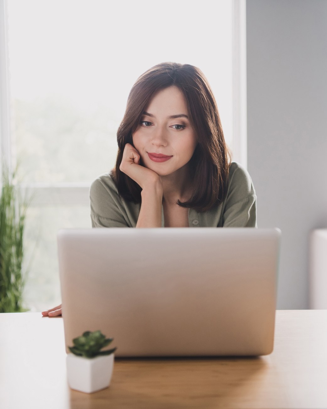 Frau sitzt am Schreibtisch und schaut auf einen Laptop, © Adobe Stock Frau sitzt am Schreibtisch und schaut auf einen Laptop, © Adobe Stock
