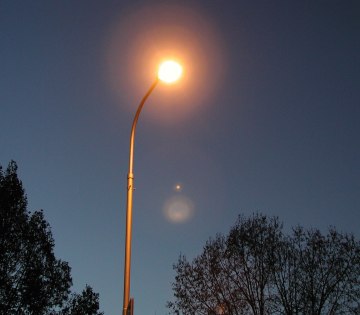 Zu sehen ist eine angeschaltete Stra&szlig;enlaterne, es ist Nacht