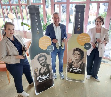 Natursolehaltige Durstlöscher für die Kurstadt: Bad Salzuflens Bürgermeister Dirk Tolkemitt (Mitte), Kurparkhotel-Inhaberin Swetlana Lenger (links) und Myriam Heidemann (rechts, Fachdienstleiterin Kulturelle Bildung, Event und Stadtmarketing)
freuen sich, die neuen Getränkesorten „Gustavs Helles Sole-Bier“ und „Sophies Sole-Limo“ am 23. Juli auf
dem Roten Platz vor dem Kurgastzentrum offiziell vorzustellen., © Stadt Bad Salzuflen